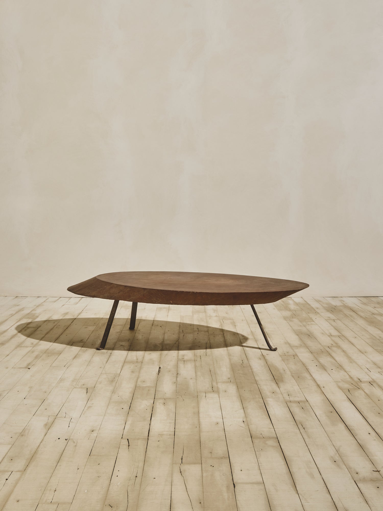 Medium brown stain oval ambiance coffee table with a thick chamfered, live-edge top and forged metal cabriole legs