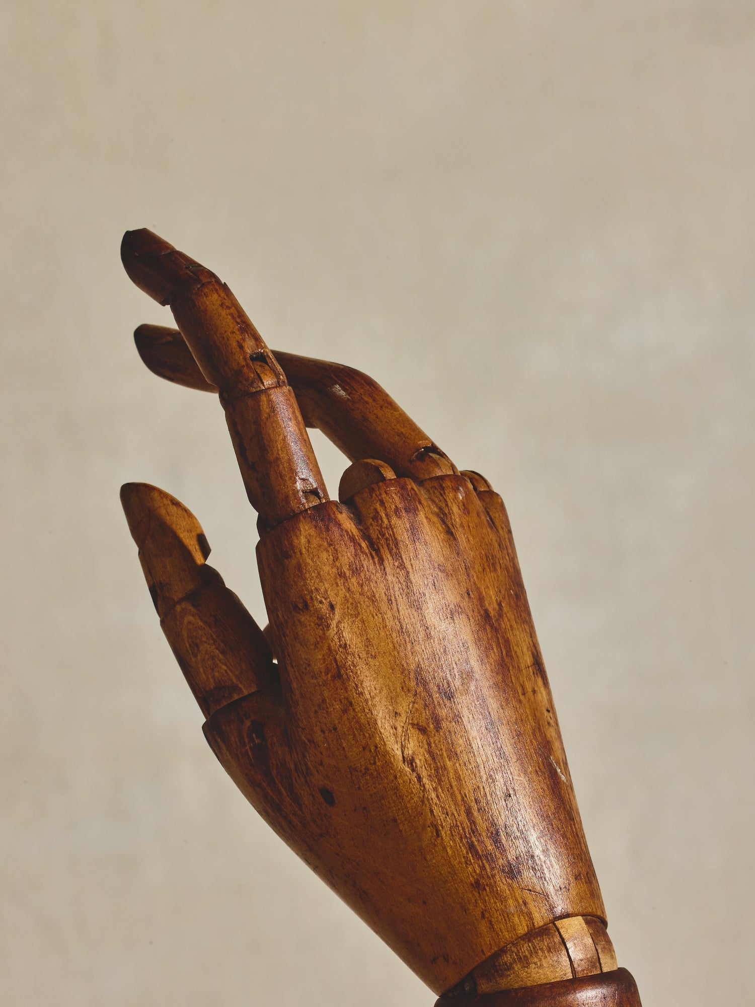 Articulated mannequin hand, on metal pedestal.