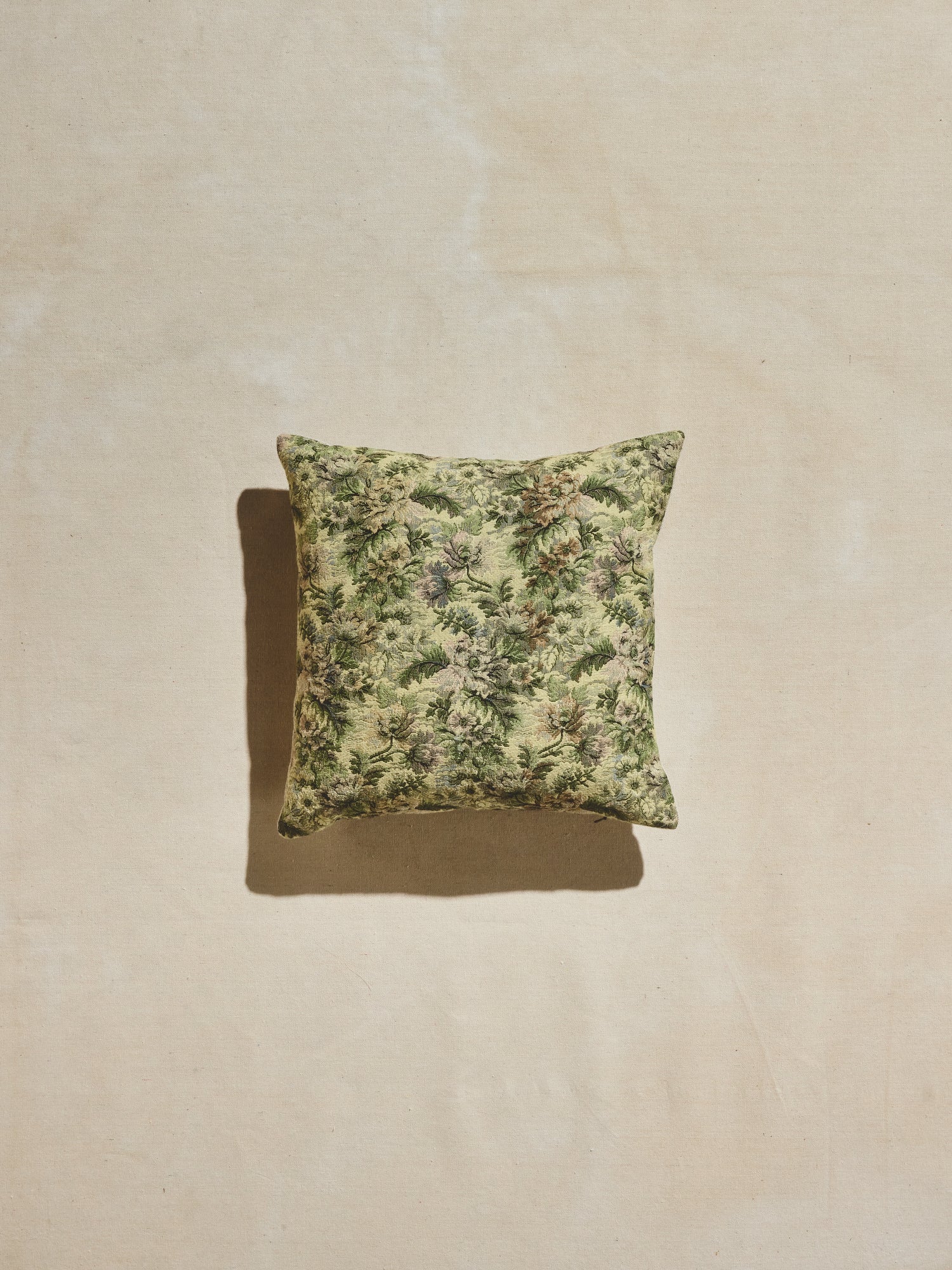 Green floral woven pillow with multi-tonal greens with pastel accents.