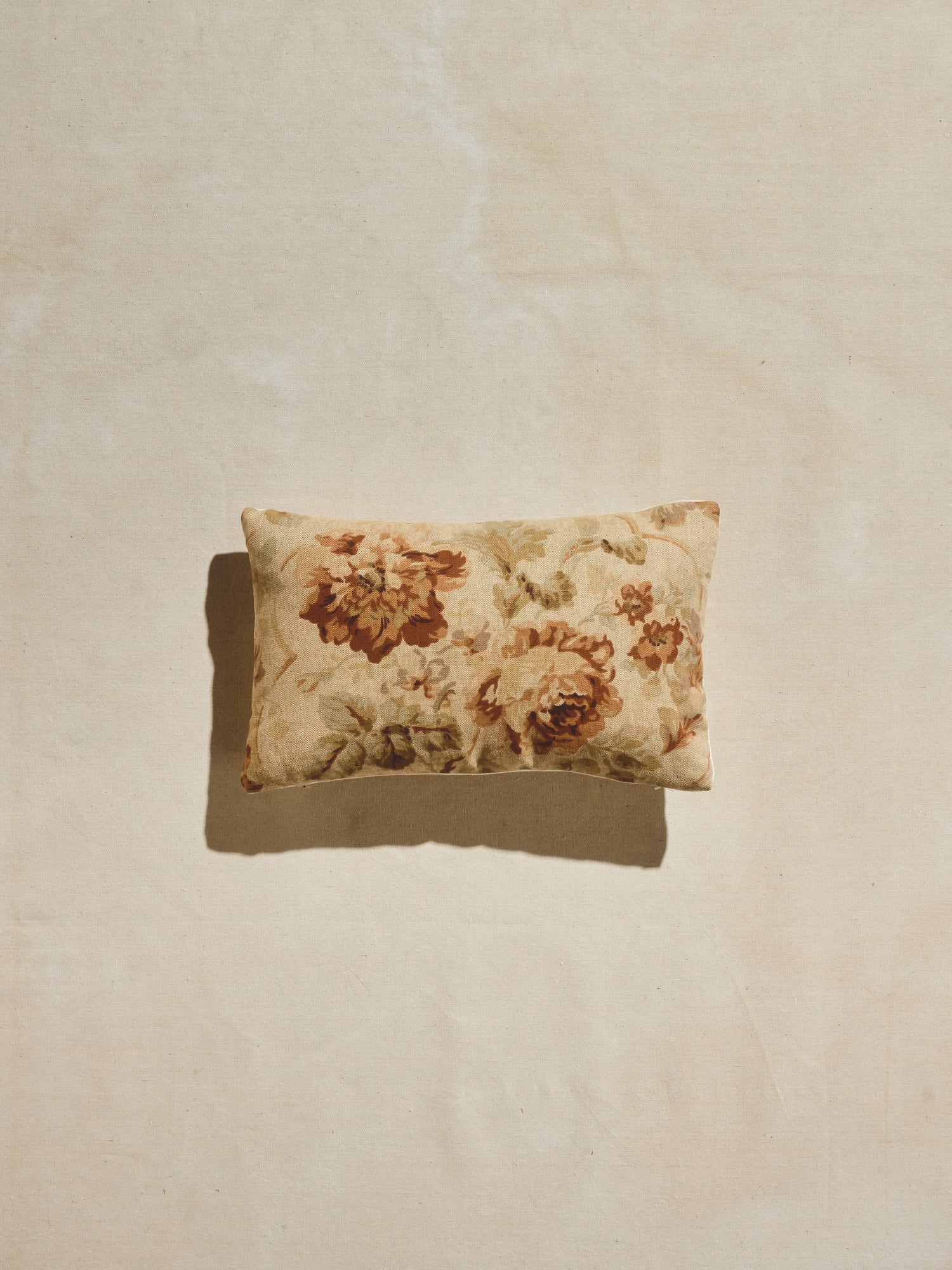 Warm pastels and rust hues floral patterned woven rectangular pillow.