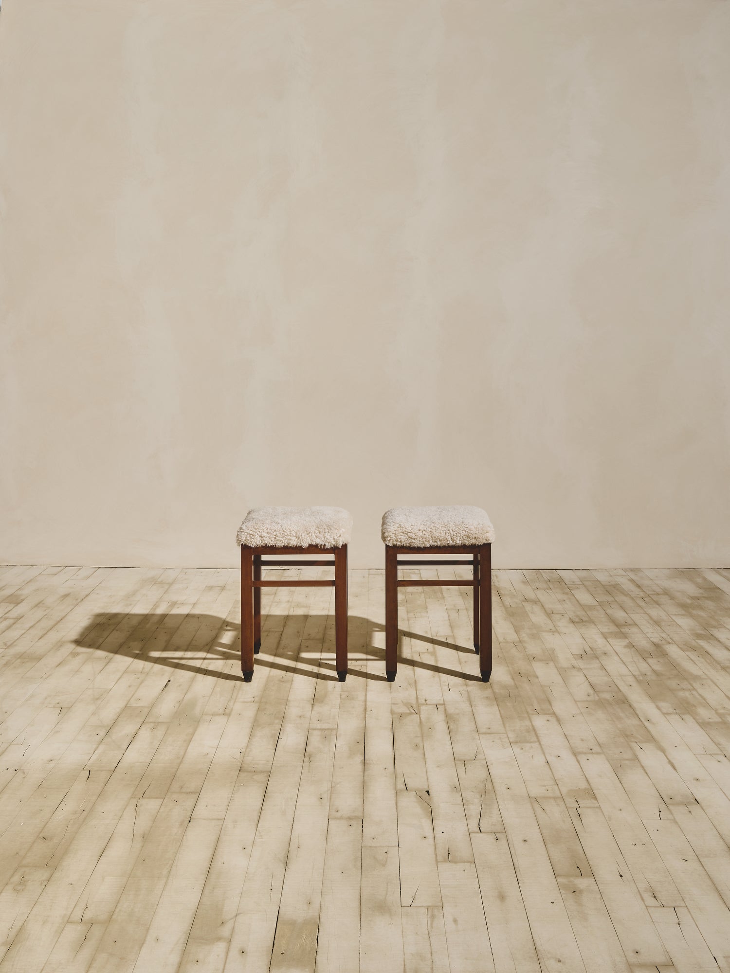 Art Deco stools that have been reupholstered in cream shearling.