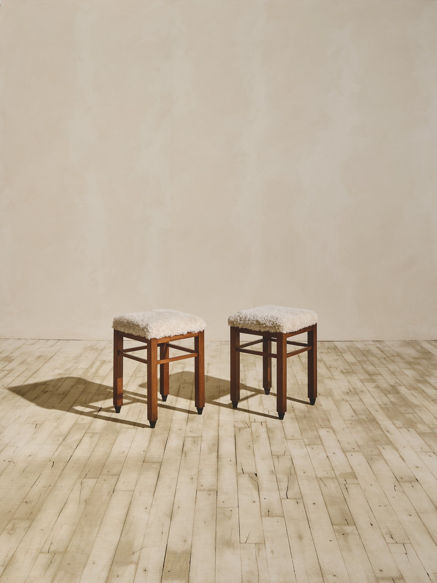 Art Deco stools that have been reupholstered in cream shearling.