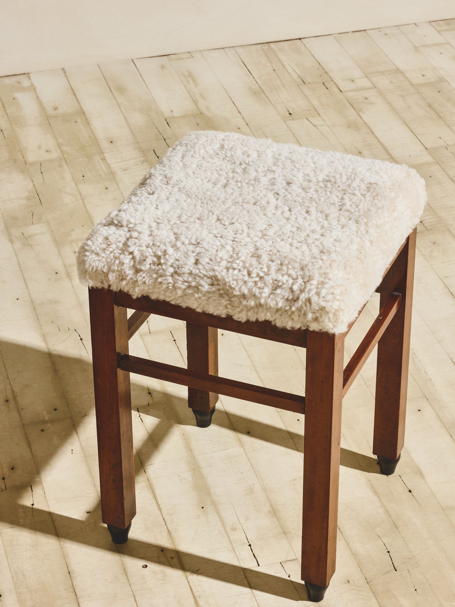 Art Deco stools that have been reupholstered in cream shearling.