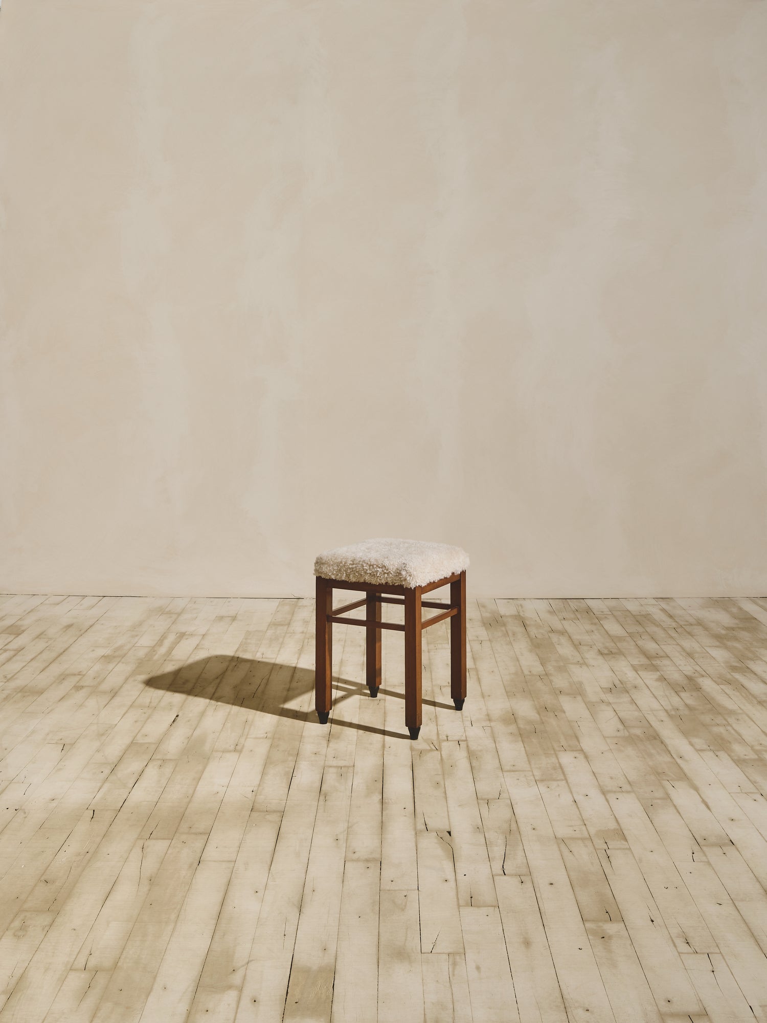 Art Deco stools that have been reupholstered in cream shearling.