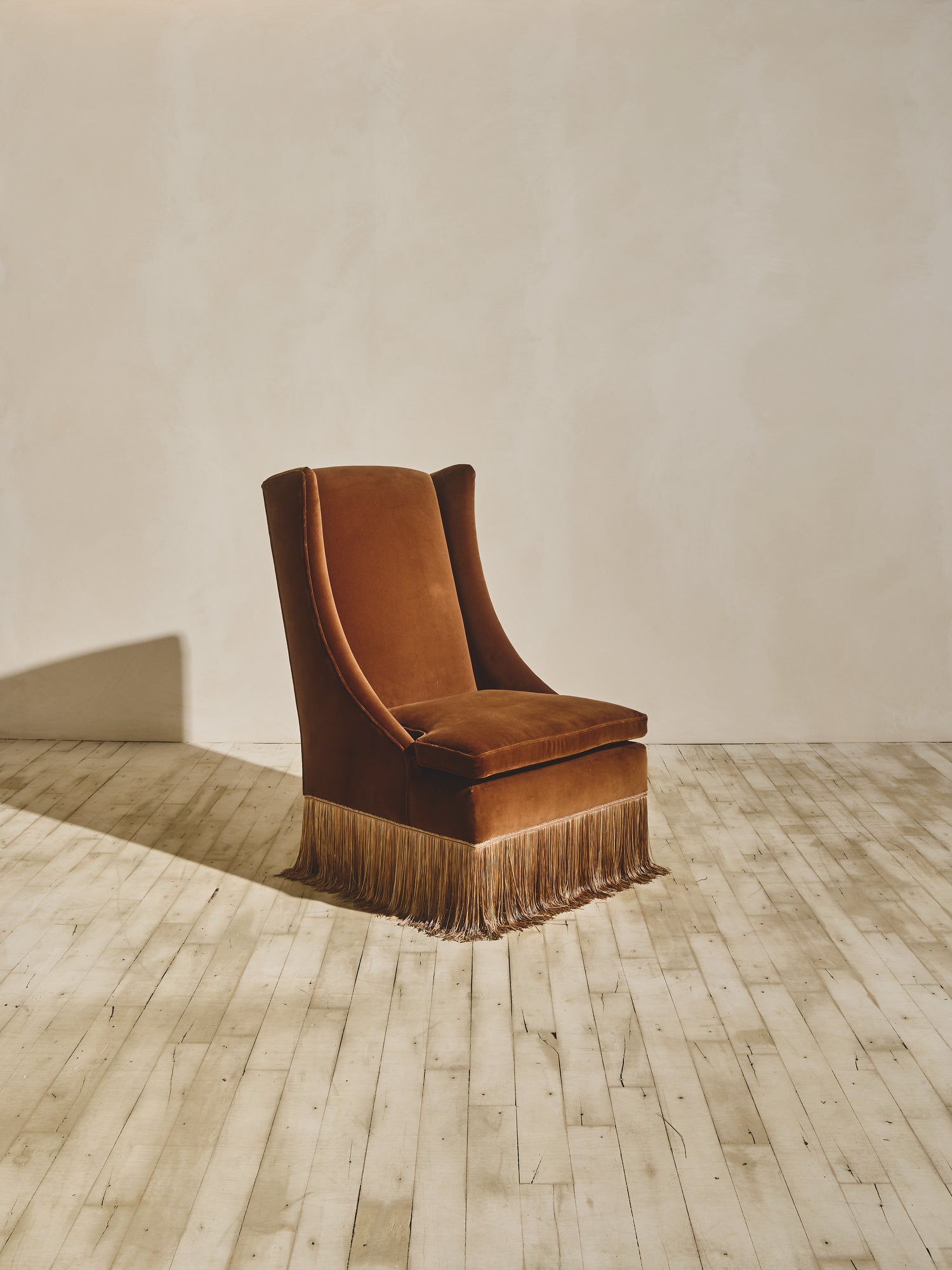 European inspired high back winged chair shown in our ochre fabric paired with our bronze fringe.