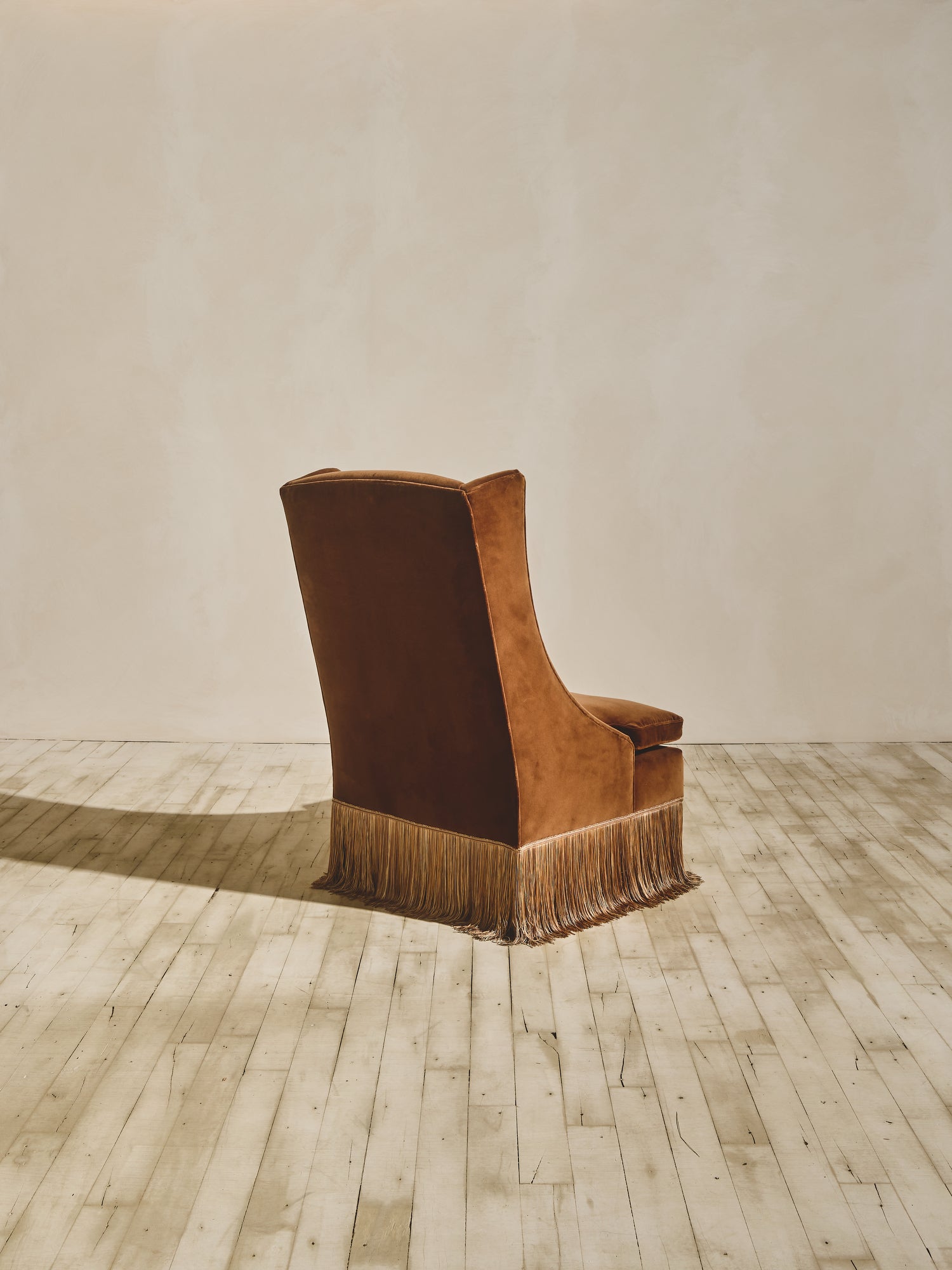 Back view of the Pavillion Chair with high back winged chair shown in our ochre fabric paired with our bronze fringe.