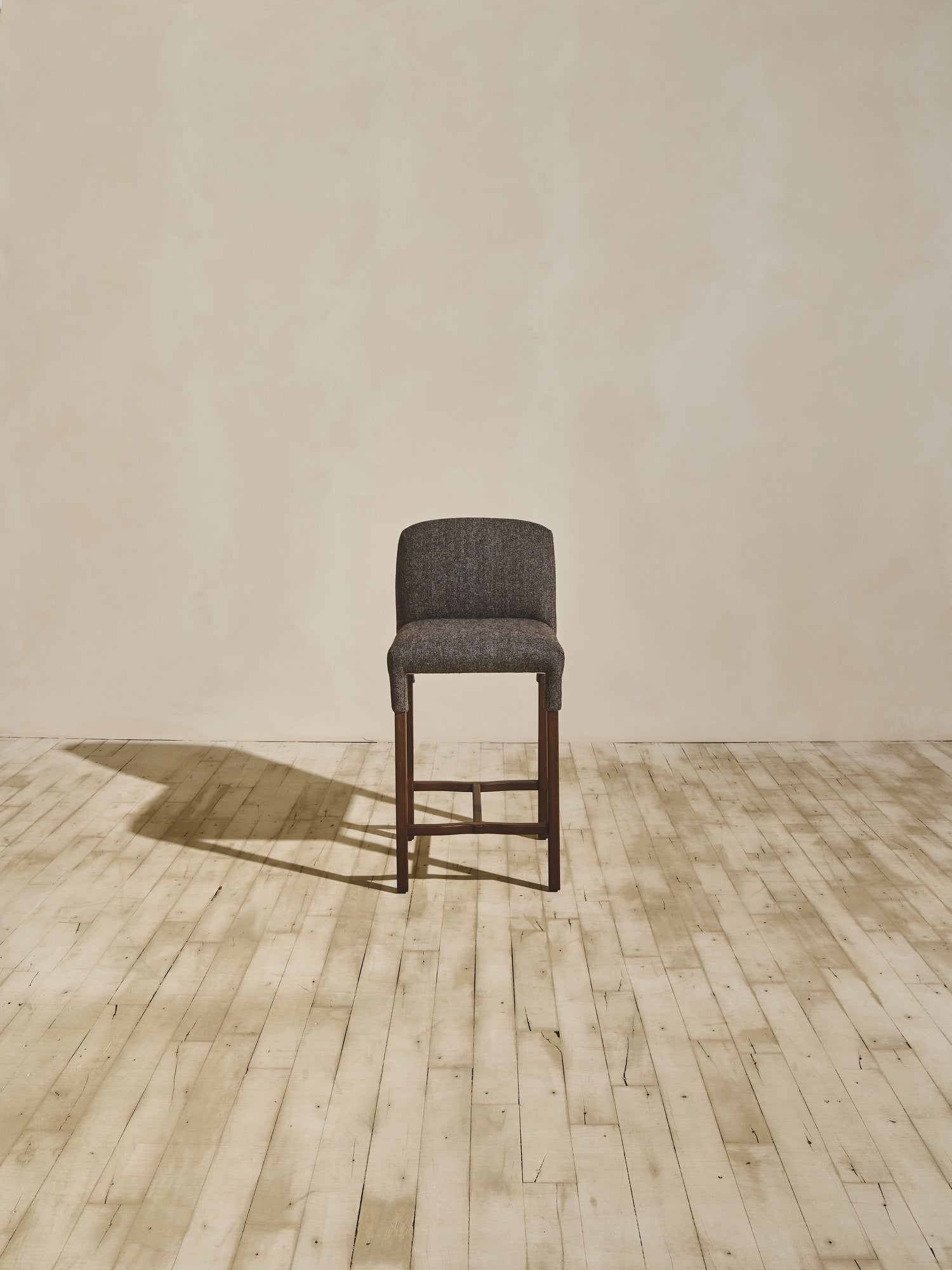 Heritage version of Mr. Wolcott curved back counter stool in natural finish and upholstered fabric seating.