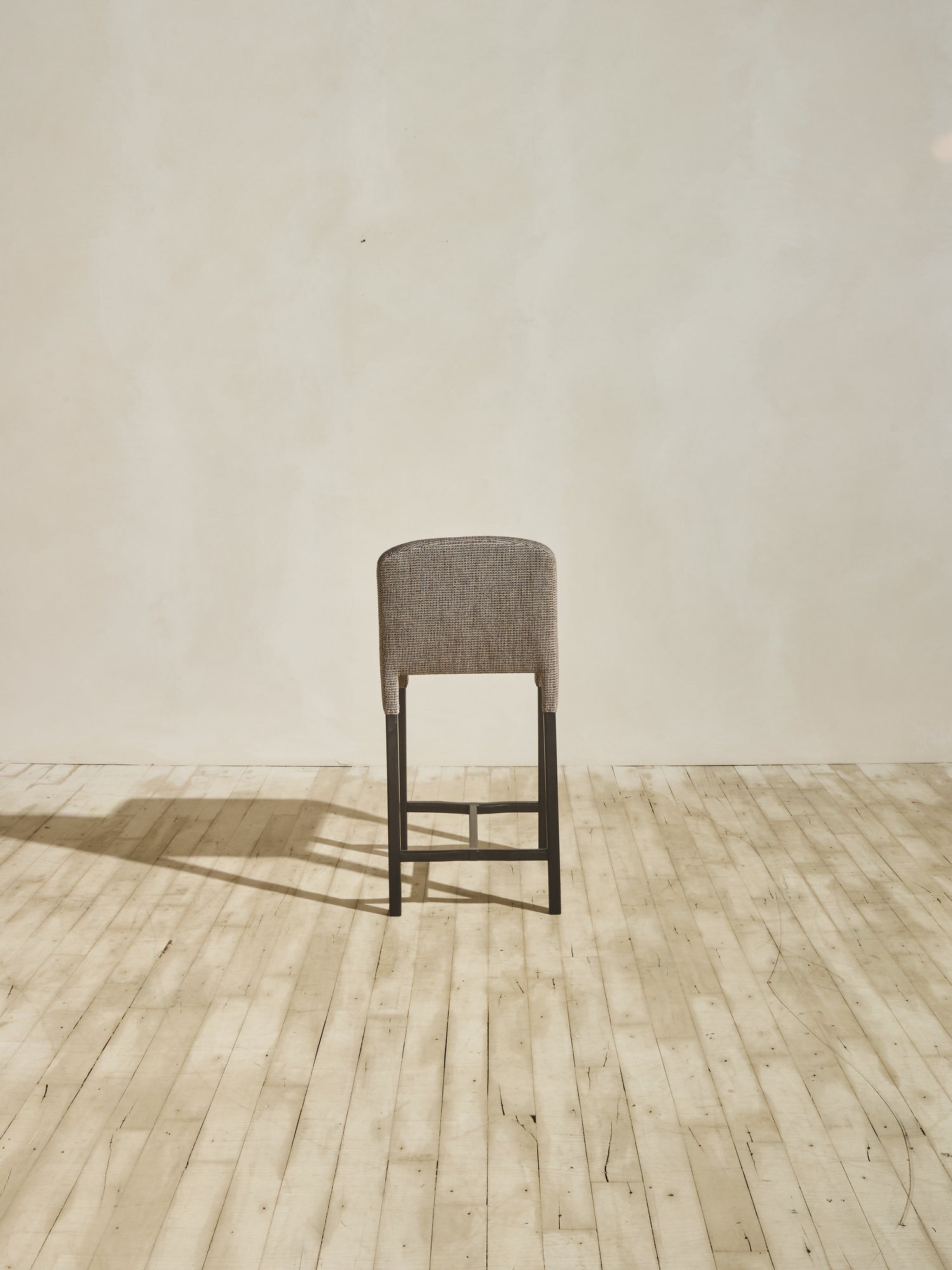 Back view of Mr. Wolcott Counter Stool with curved back and sleek silhouette.
