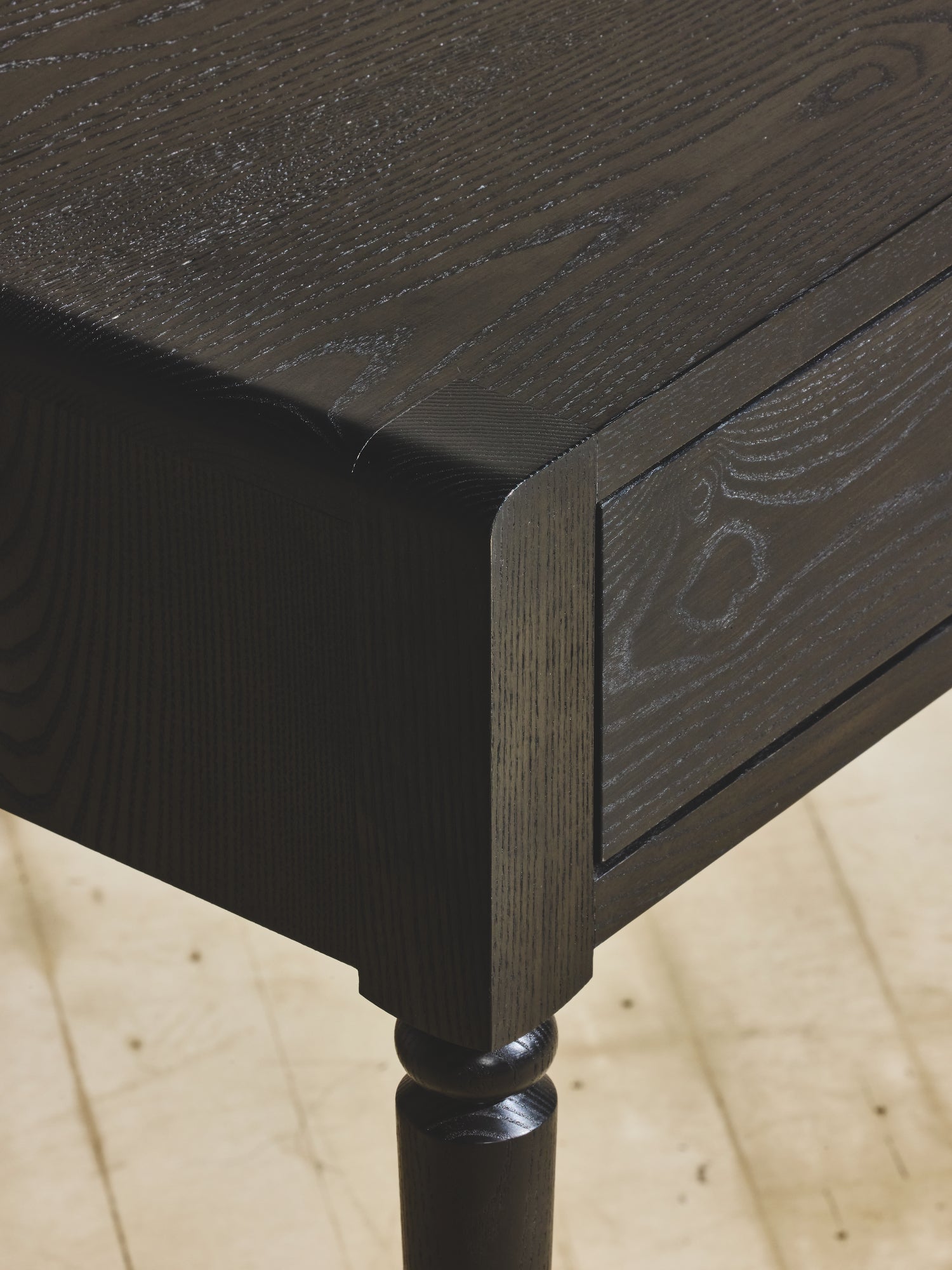 Close of up the oak wood grain in ebony finish on the Disc Desk.