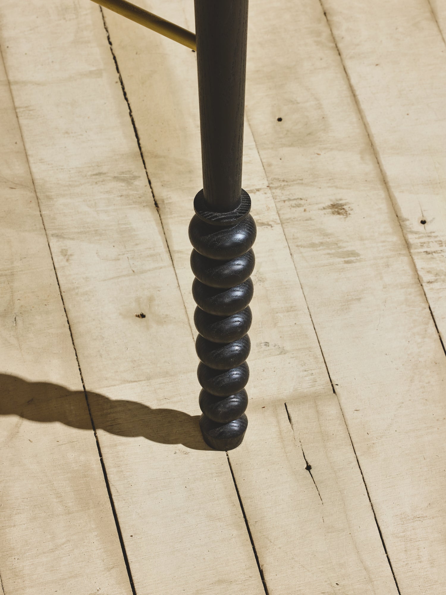 Close up of the ornate, geometric leg turnings on the vintage style Disc Desk with ebony staining.