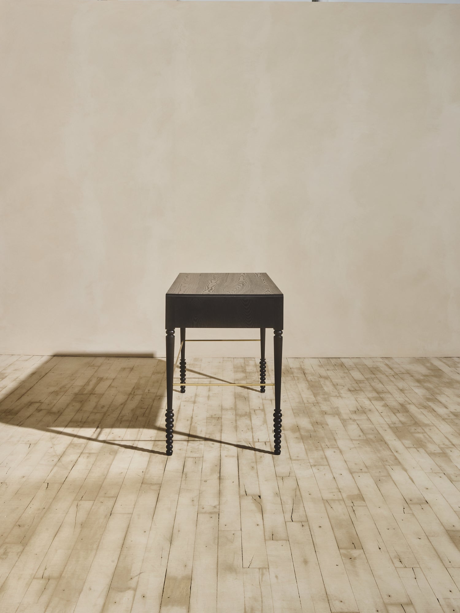 Side view of mid century modern Disc Desk featuring oak wood construction, ornate geometric legs, and an elegant ebony stain.