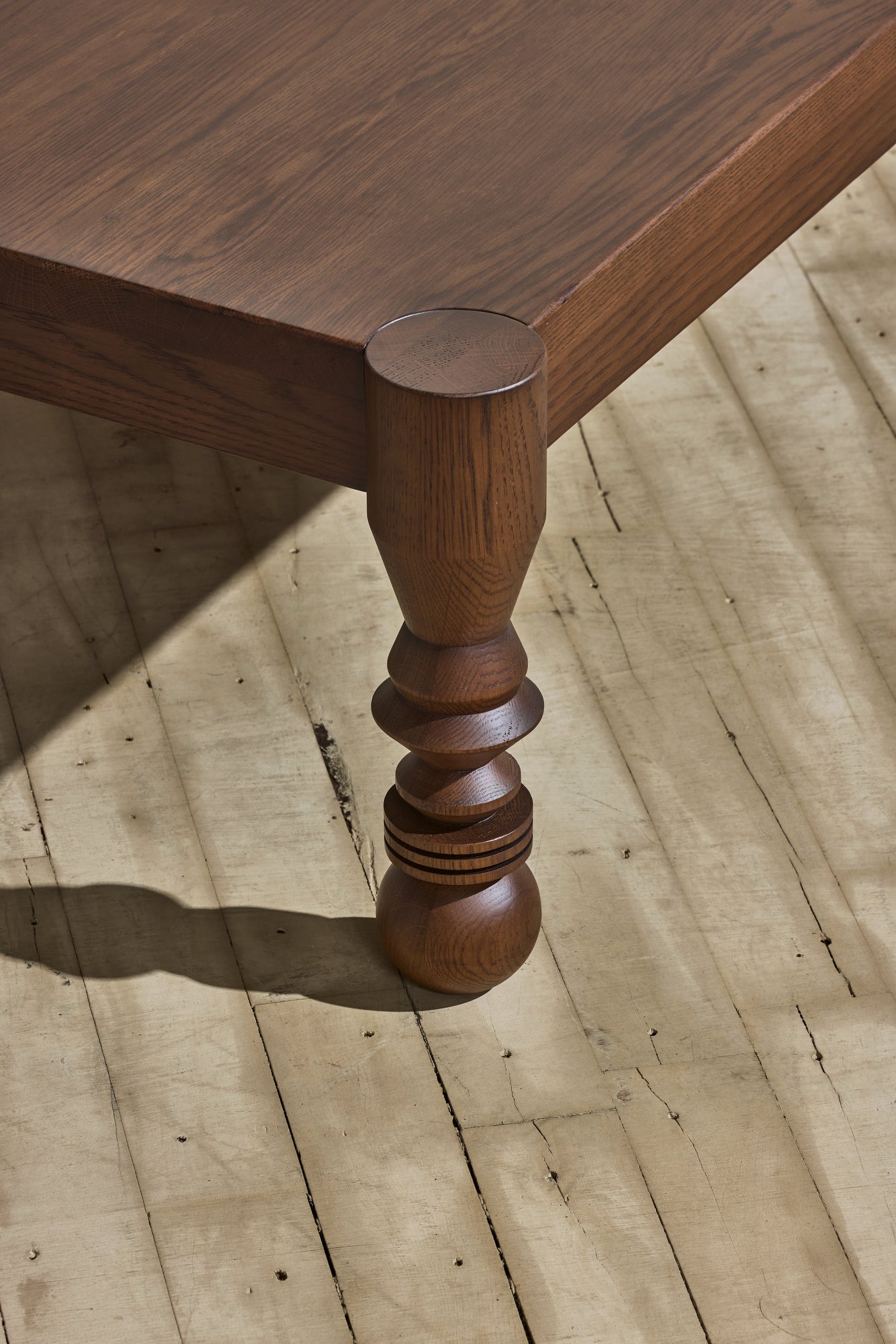 Close up of the unique leg turnings with ebony staining on the modern style NBL Dining Room Table.