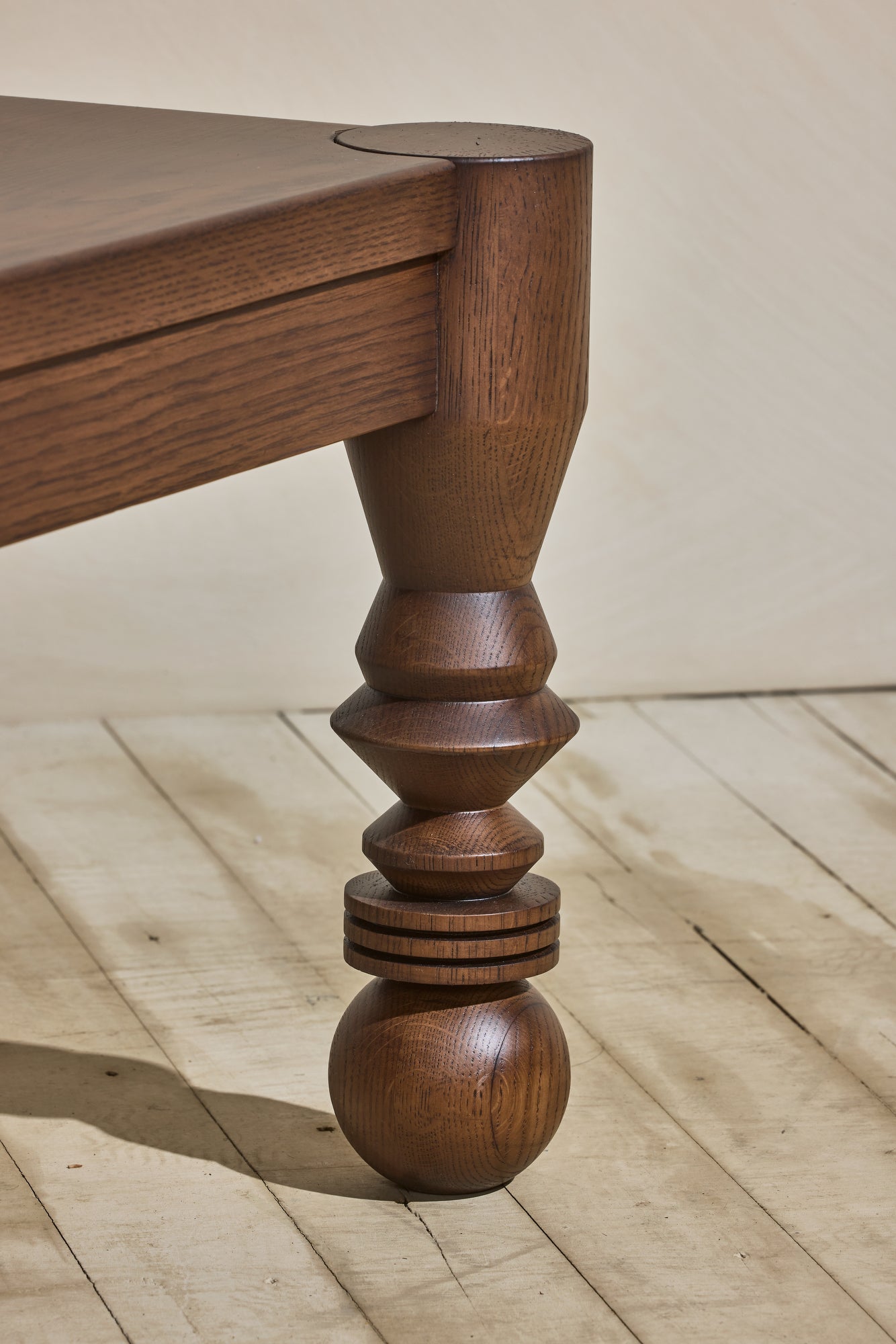 Close up of the unique leg turnings with ebony staining on the modern style NBL Dining Room Table.