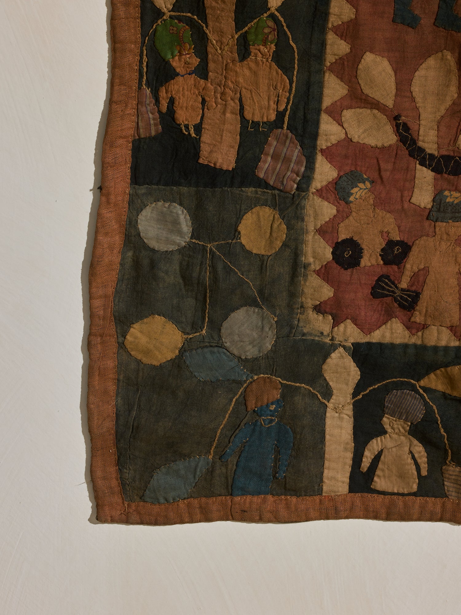 Quilted tribal tapestry, auburn, green, and yellow hues.