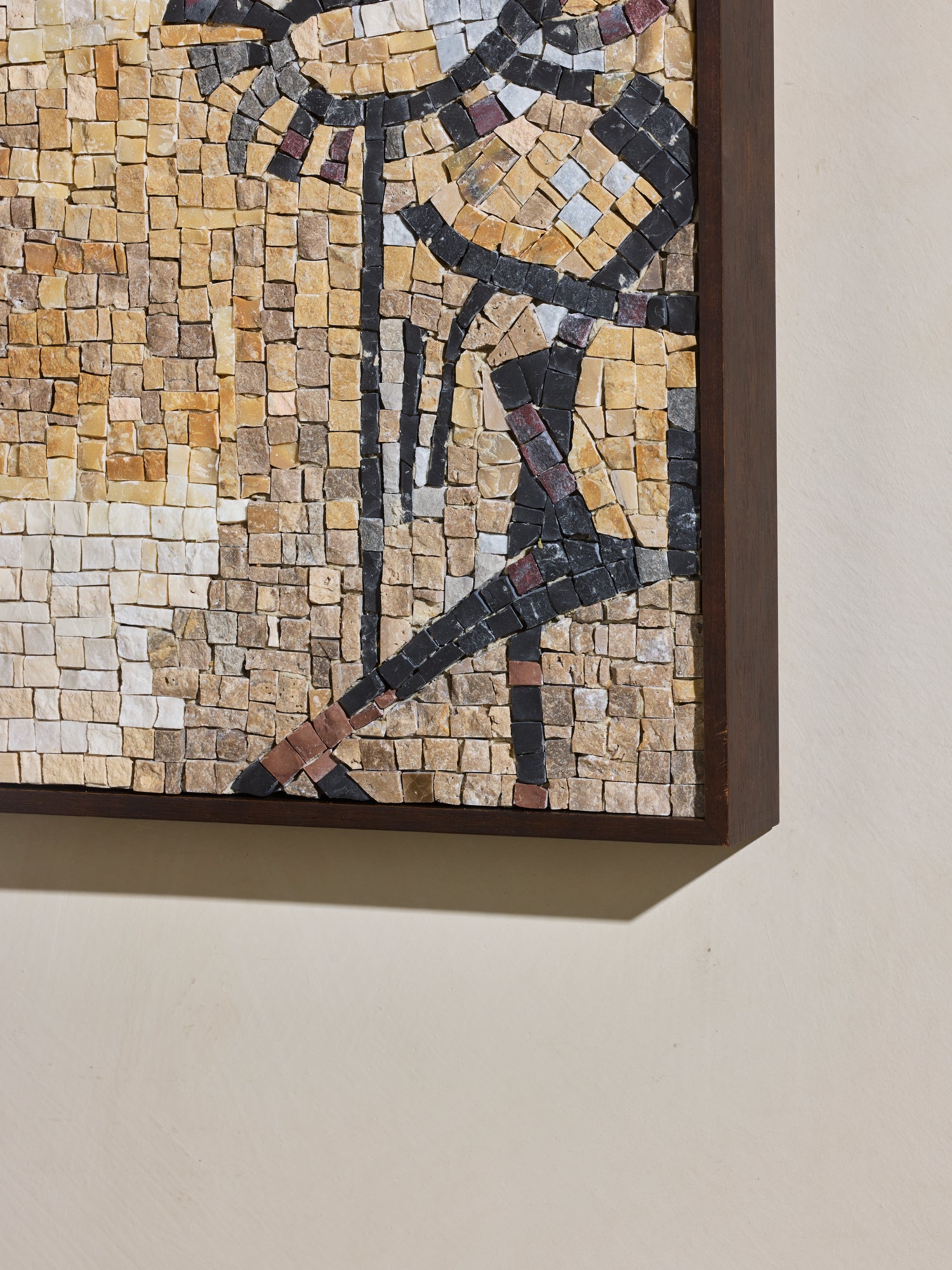 Close up of hand cut and applied stone on mosaic square stone artwork with beige, yellow, off white and black details.