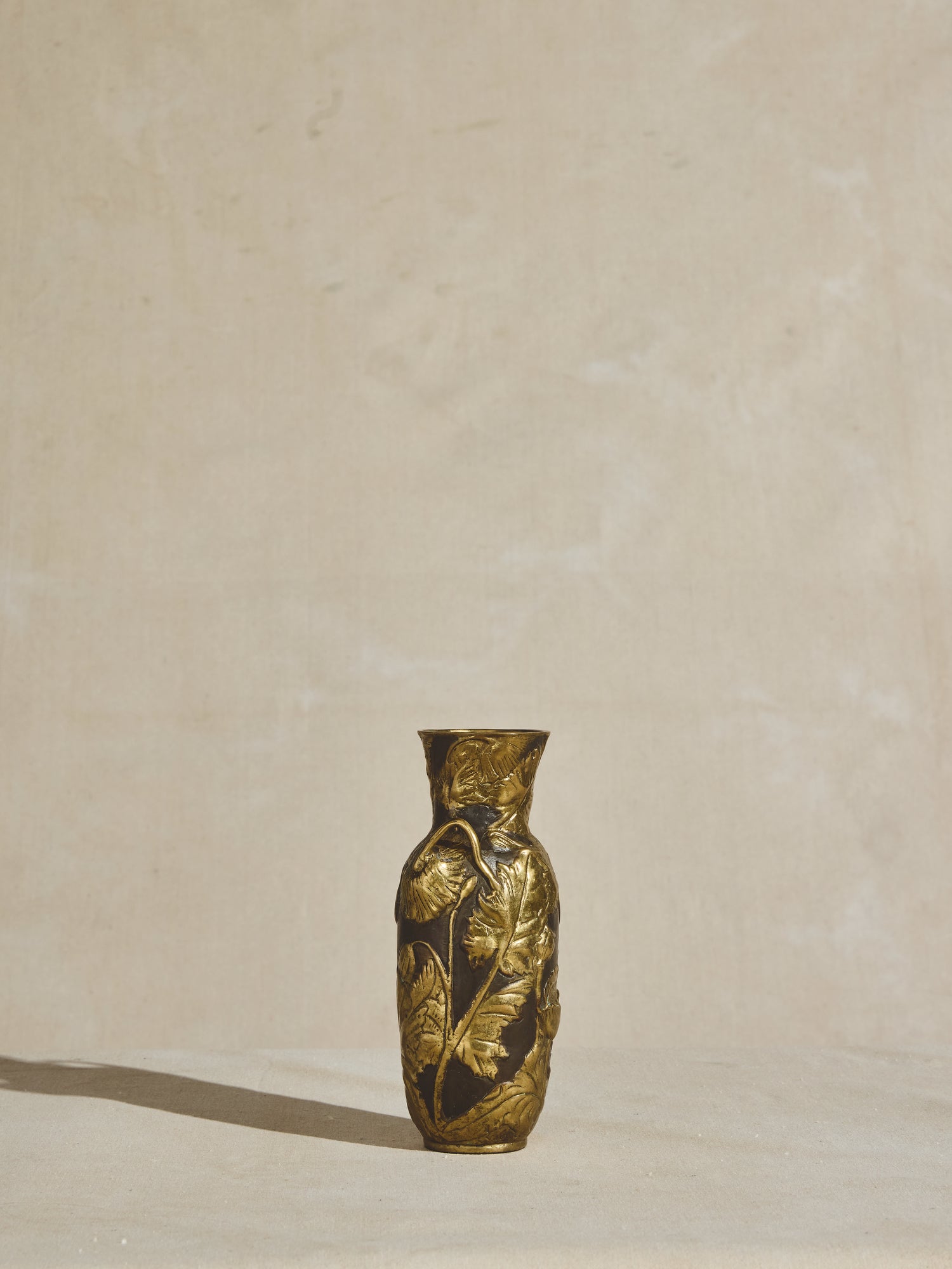 Ornate, solid bronze, art nouveau vase with tapered neck, decorative handles, and elongated body.
