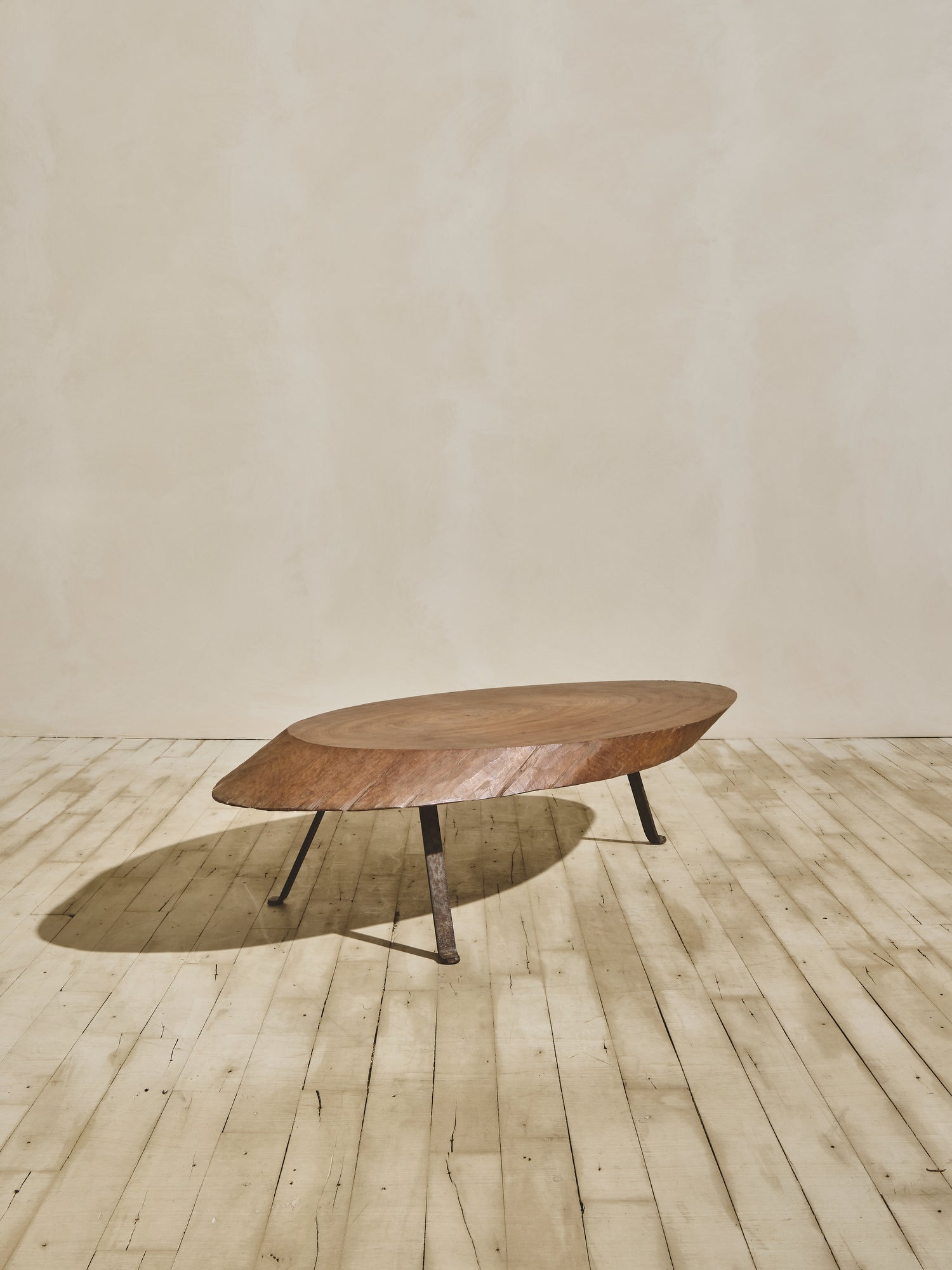 Medium brown stain oval ambiance coffee table with a thick chamfered, live-edge top and forged metal cabriole legs