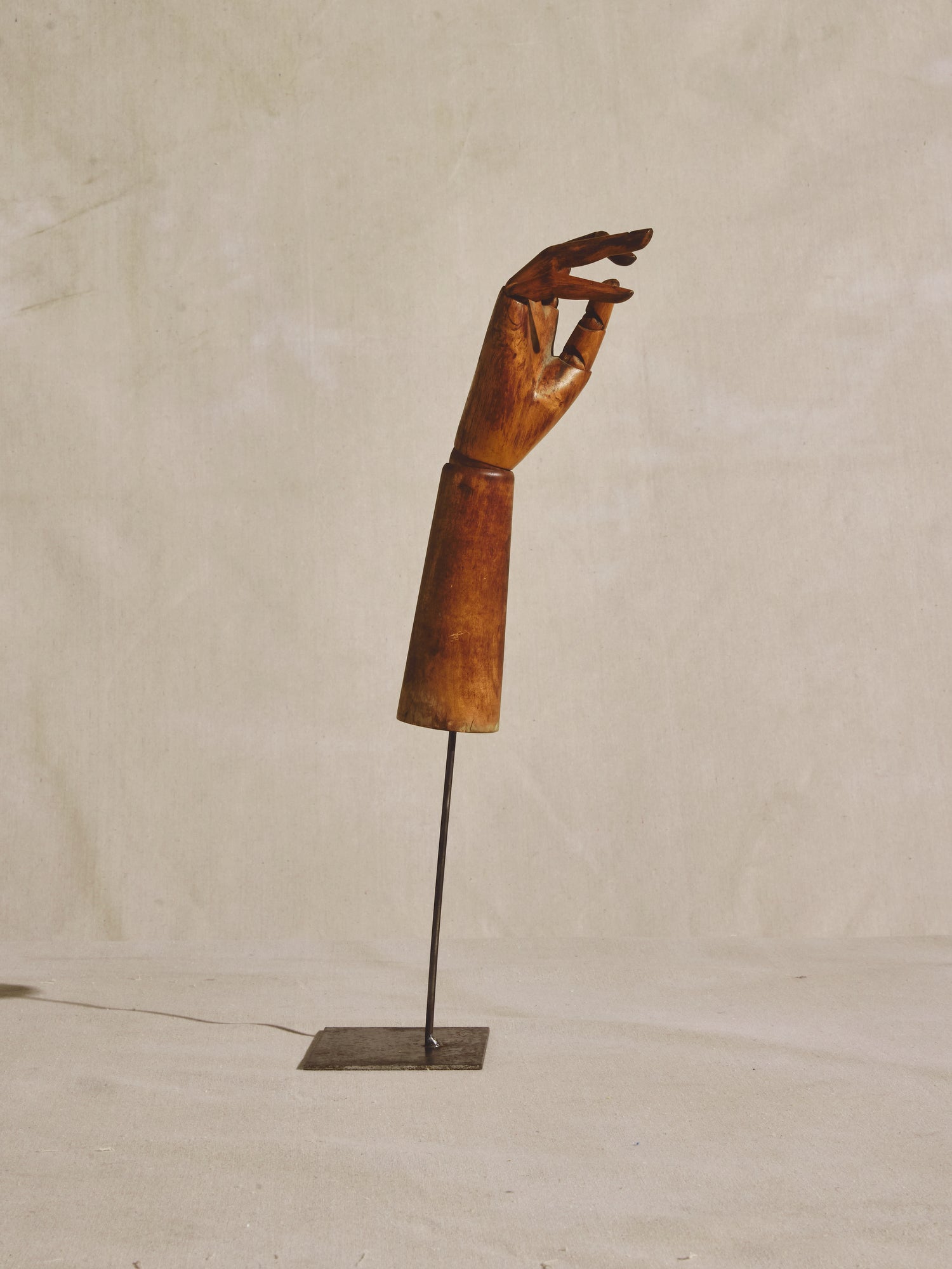 Articulated mannequin hand, on metal pedestal.