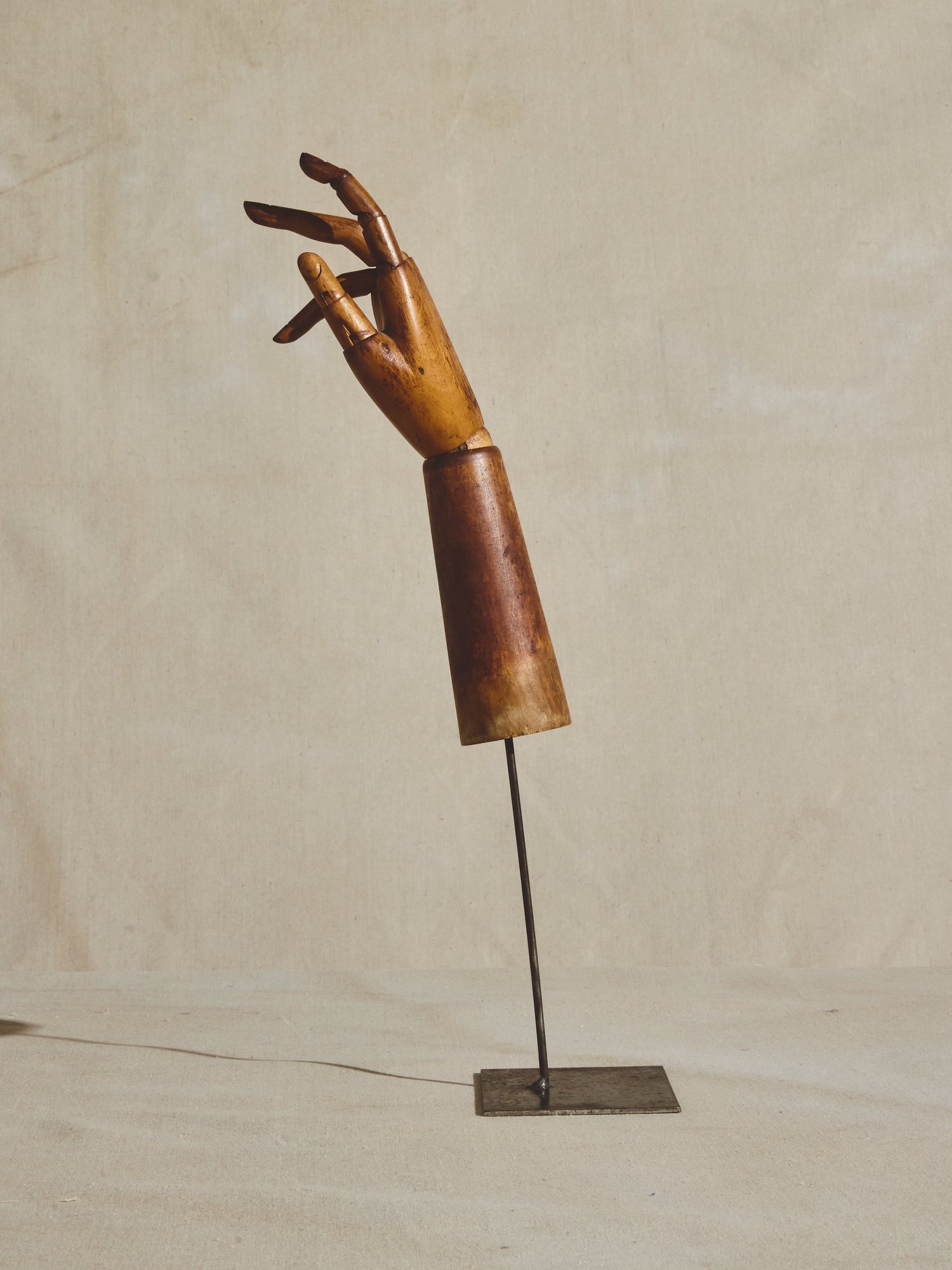 Articulated mannequin hand, on metal pedestal.
