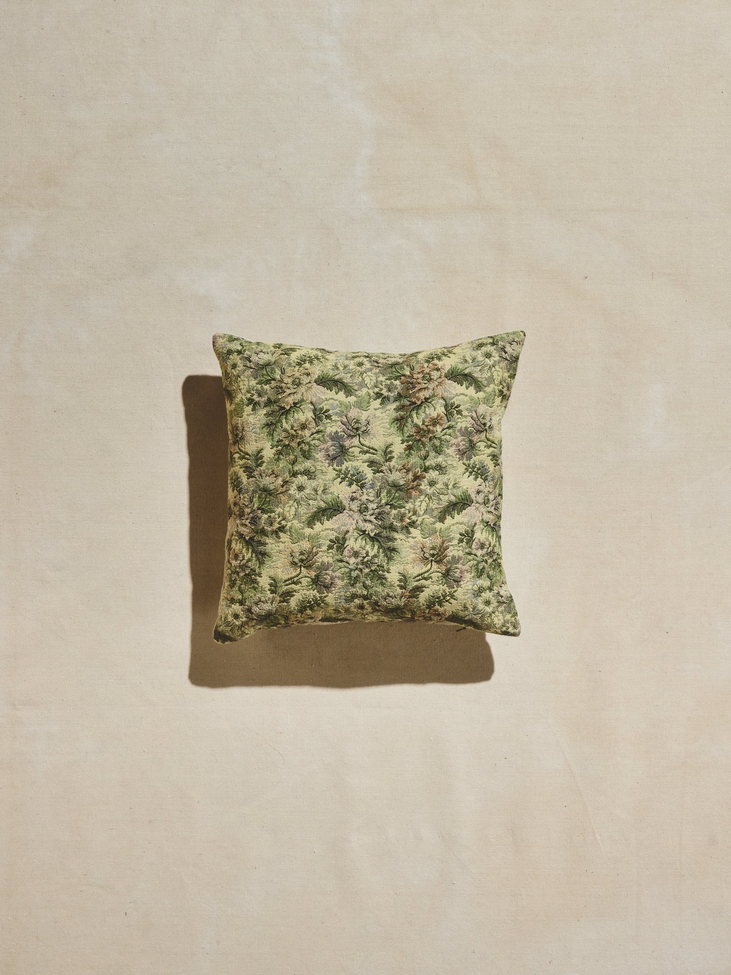 Green floral woven pillow with multi-tonal greens with pastel accents. 