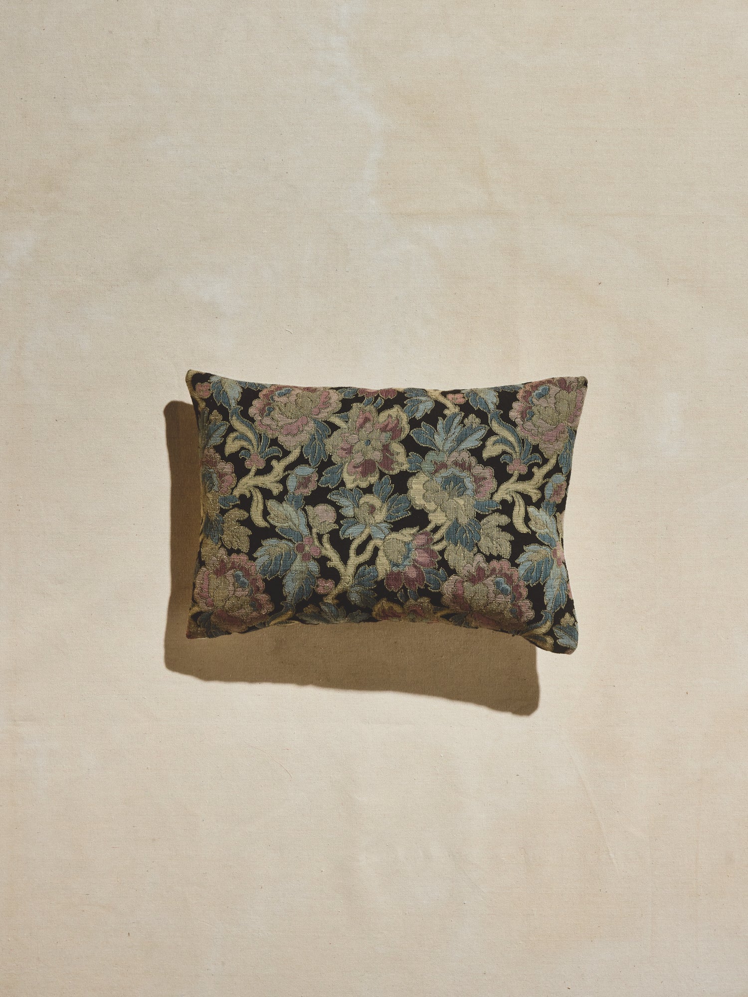 Nightshade woven floral pillow with cool tones of navy, light blue, gold, and pale pinks.