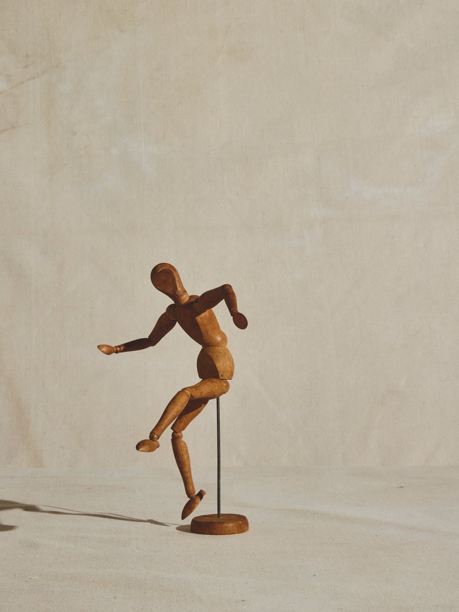 A wooden mannequin in a dance pose, on it's stand, on a white surface Stock  Photo - Alamy
