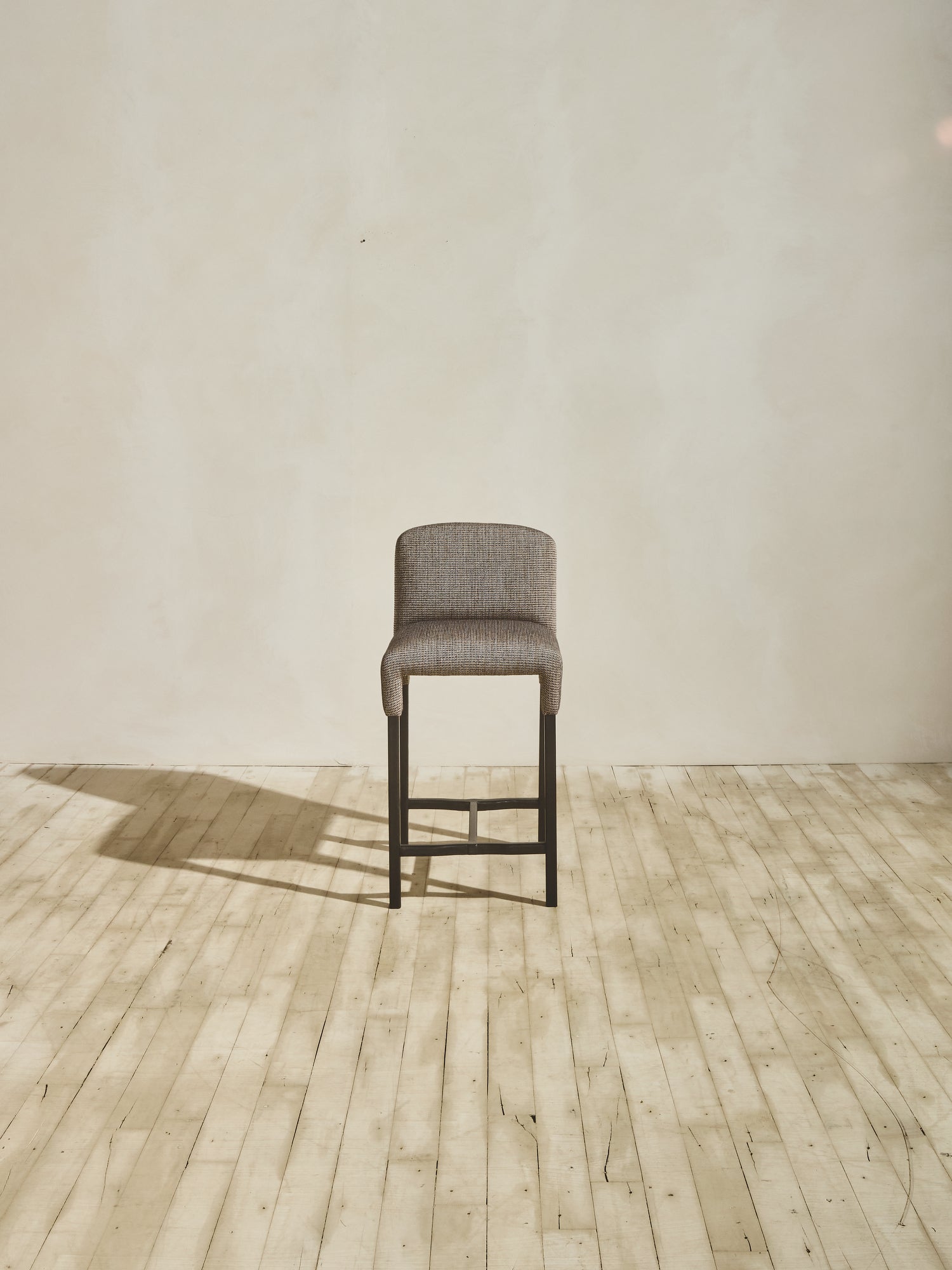 Mr. Wolcott Counter Stool with curved back and sleek silhouette.