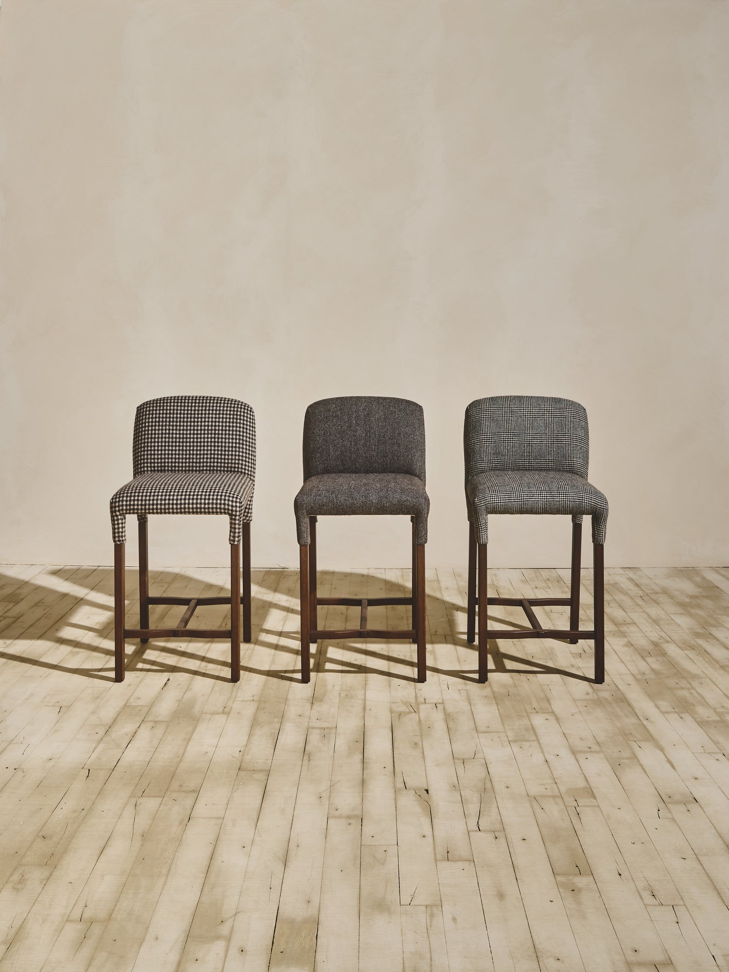 Group of heritage style Mr. Wolcott Counter Stool in natural finish and upholstered fabric seating.