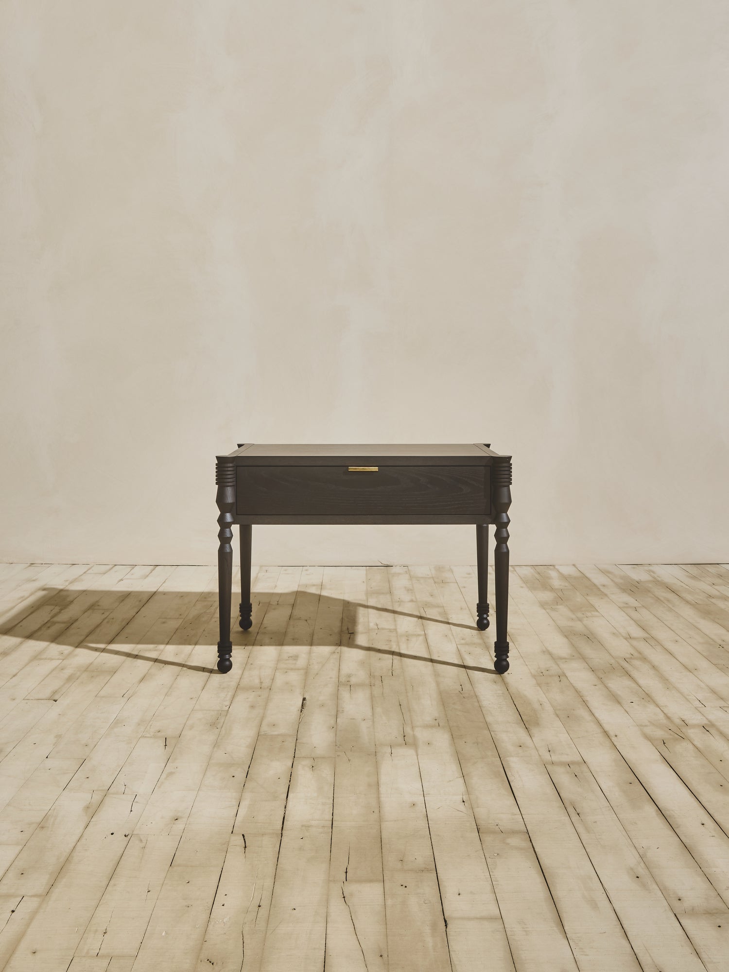 Front view of modern style wooden Disc Side Table showcasing geometric leg turnings, in ebony finish.