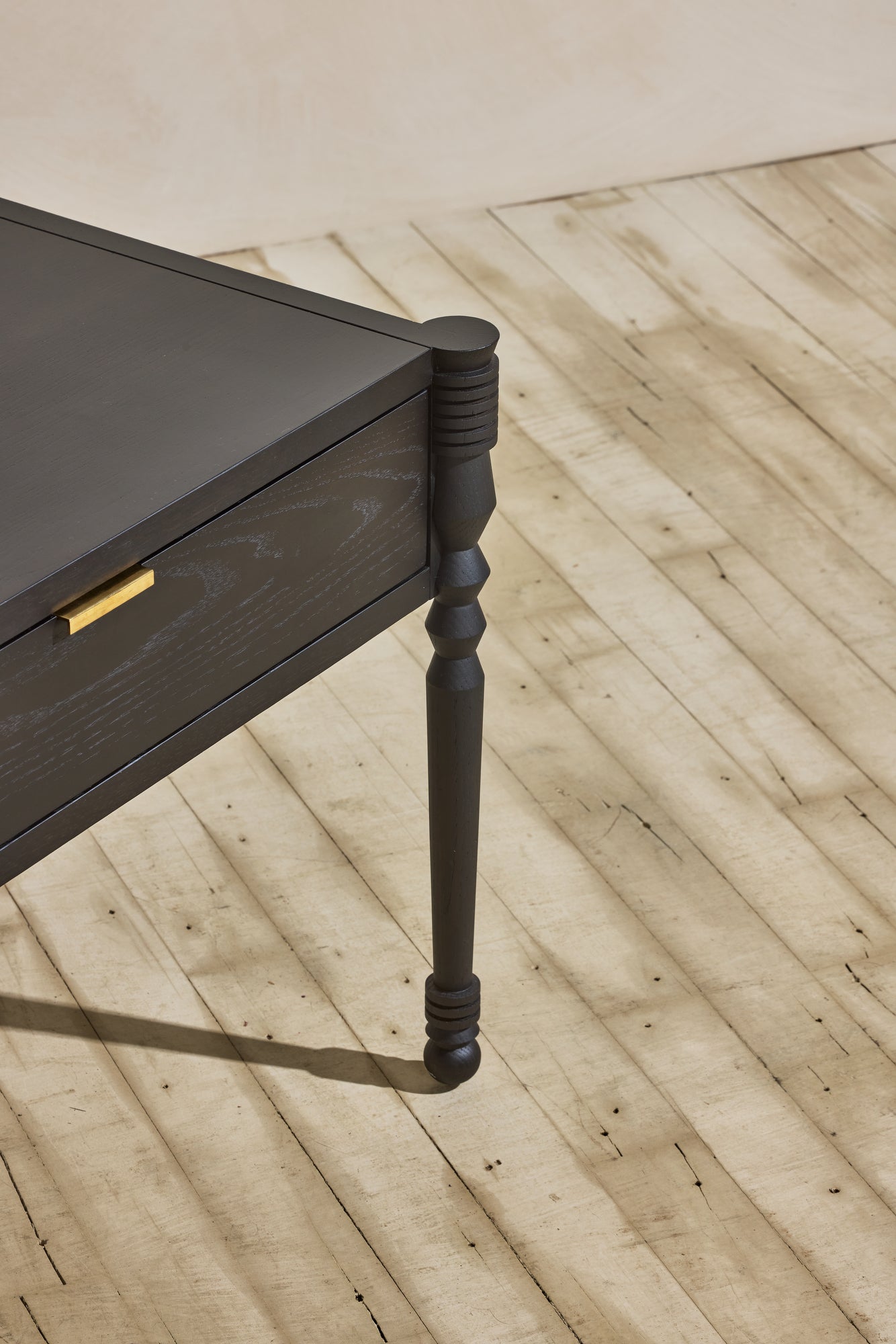 Close up of geometric leg turnings in ebony finish from Disc Side Table.