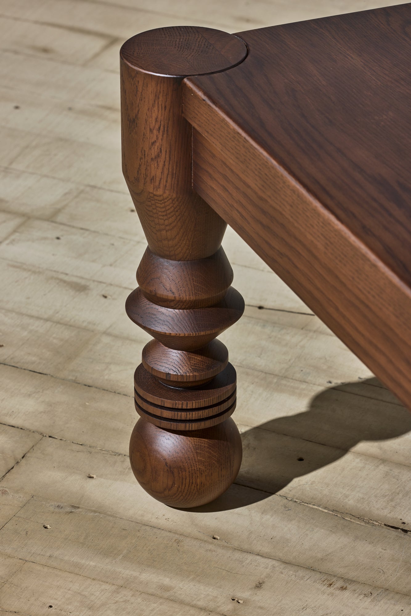 Close up of the unique leg turnings with ebony staining on the modern style NBL Dining Room Table.