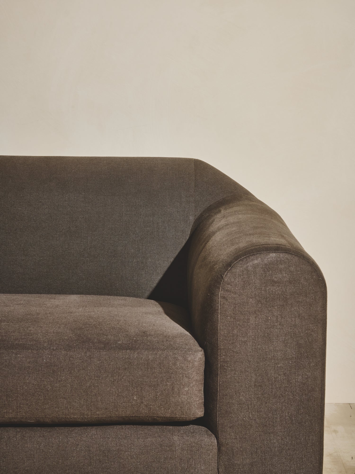 Close up of the arm rest, upholstered fabric in olive on the Sabi Sectional.