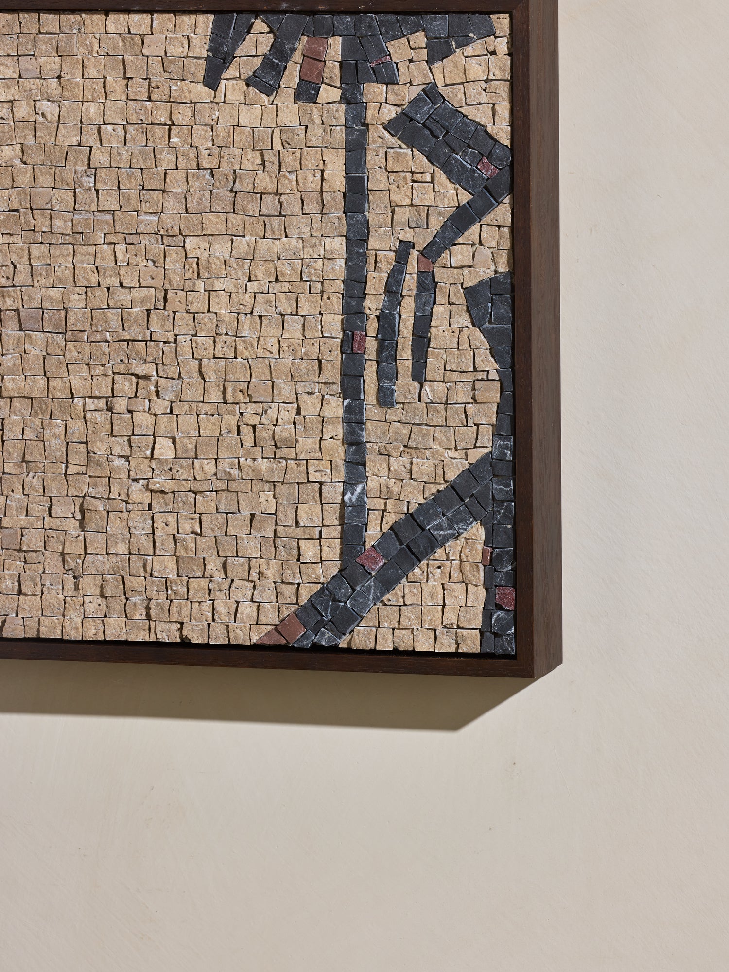Close up of mosaic square stone art piece with beige and black details and wooden framing.