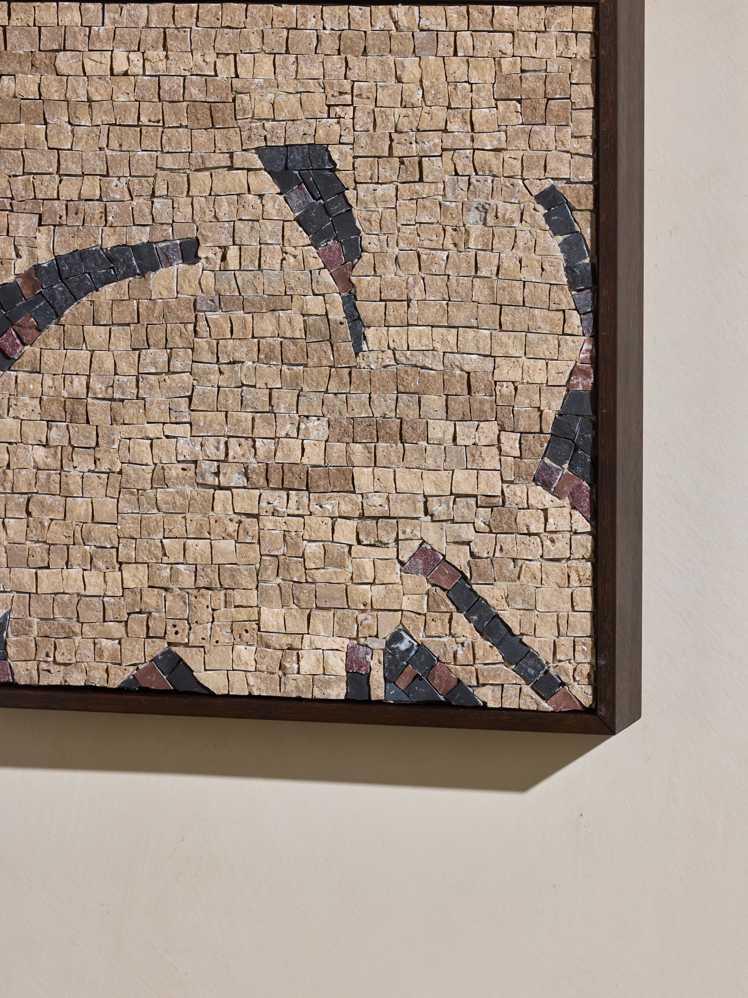 Close up of mosaic square stone art piece with beige and black details and wooden framing.