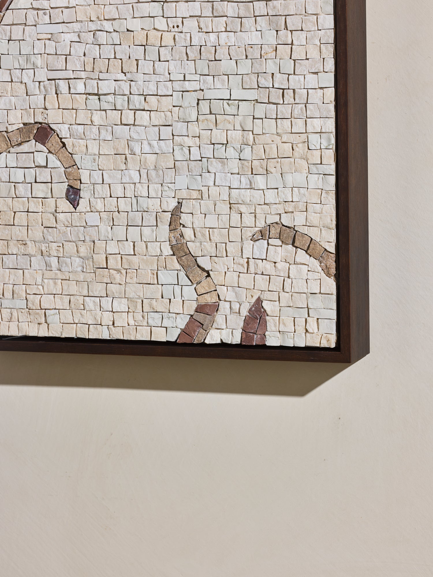 Close up of mosaic square stone art piece with off white and beige details and wooden framing.