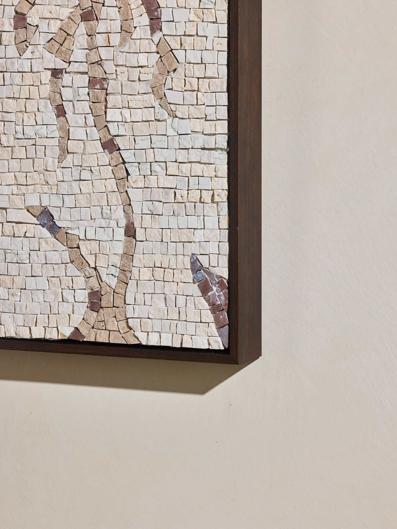 Close up of mosaic square stone art piece with off white and beige details and wooden framing.