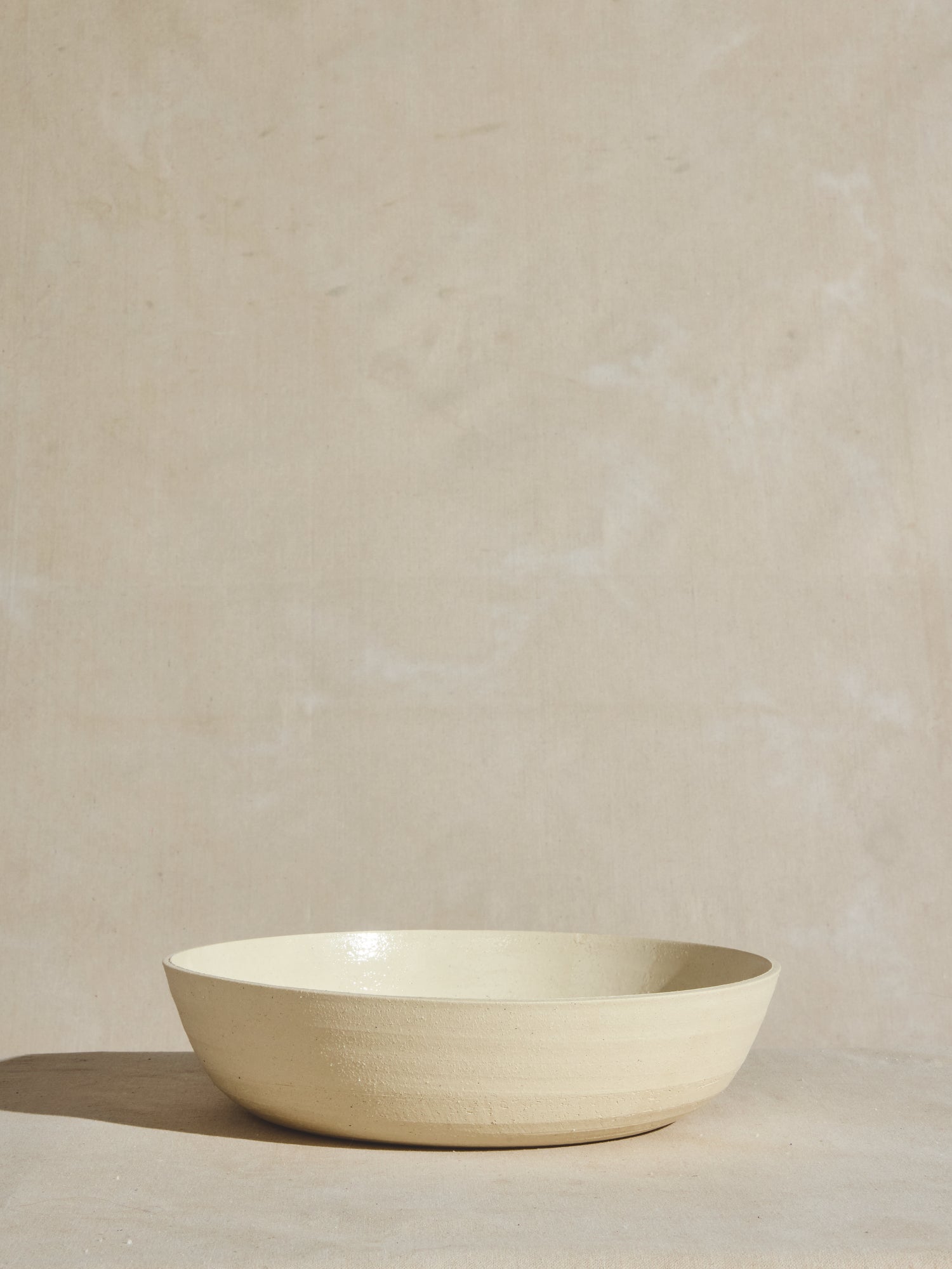 Hand thrown ceramic serving salad bowl stacked in natural finish.